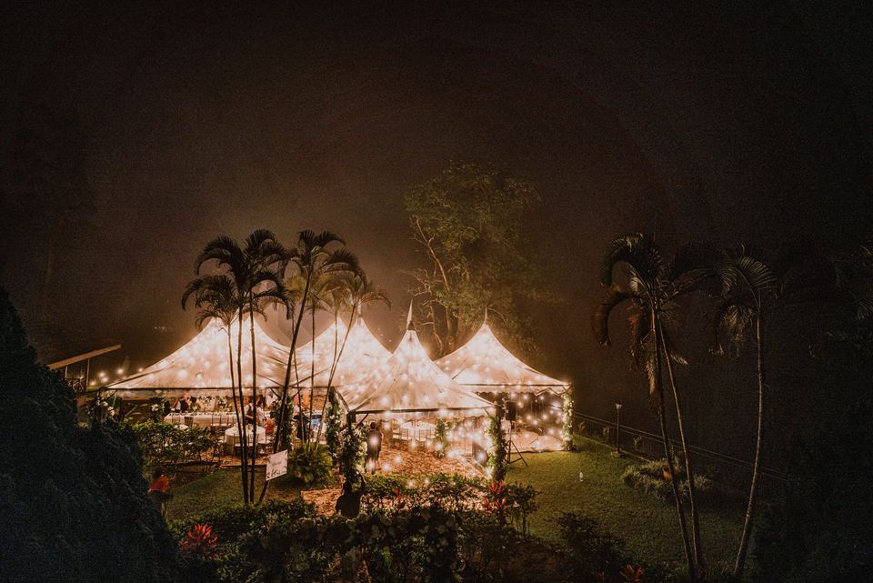 Lit peak tents on the lawn at night