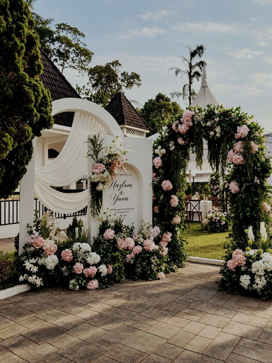 Welcome sign and floral arch at the entrance to the lawn