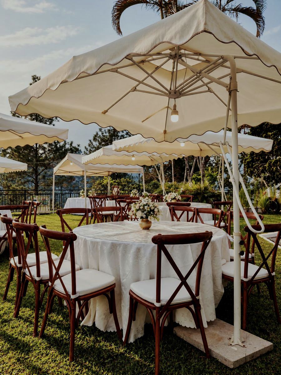 Reception tables under scalloped umbrellas on the lawn