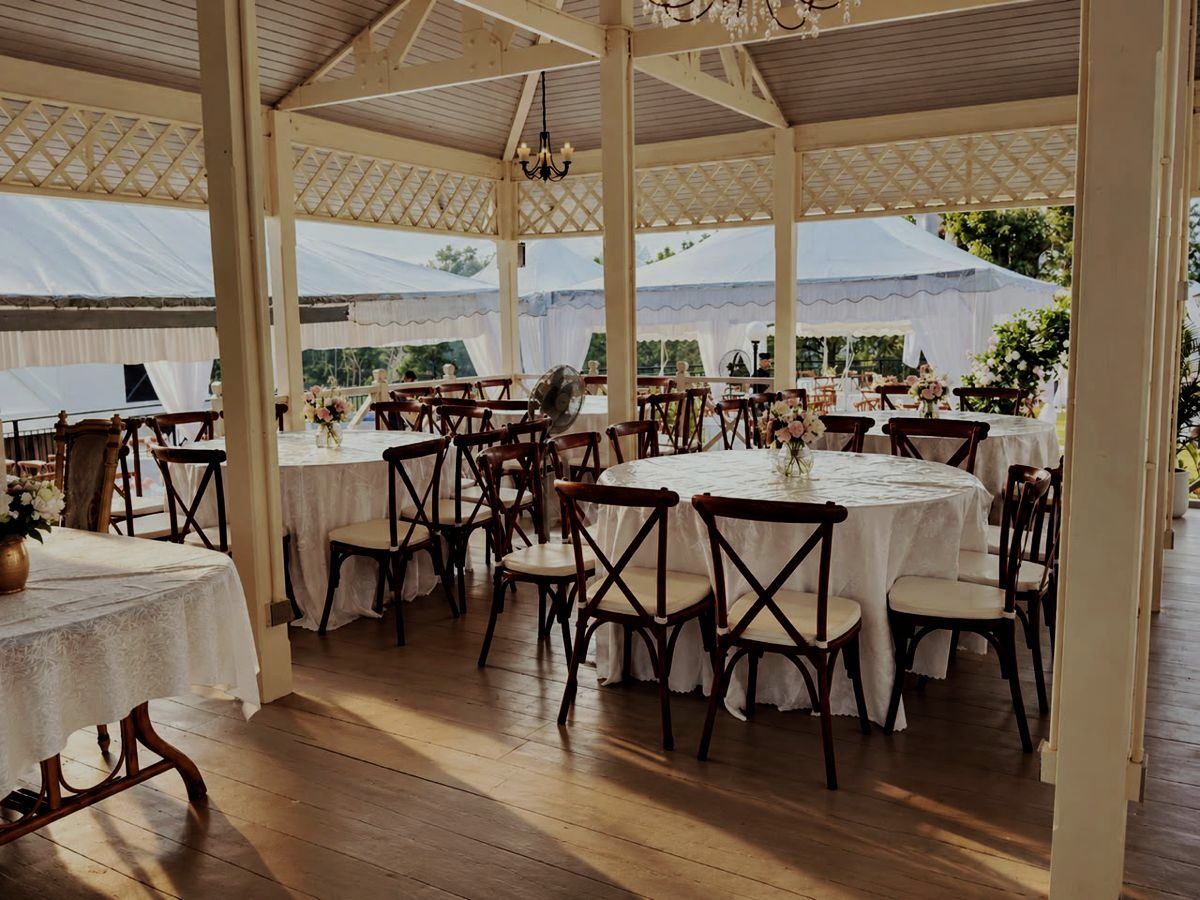 Covered pavilion set with round tables and cross-back chairs